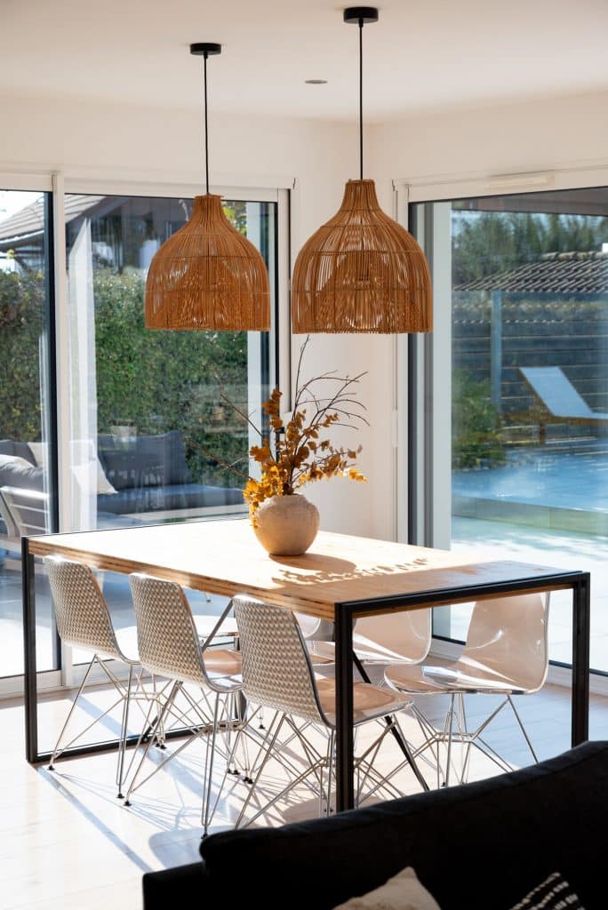 Séjour moderne lumineux ouvert par baies vitrées sur une terrasse ensoleillée par architecte d'intérieur Annecy
